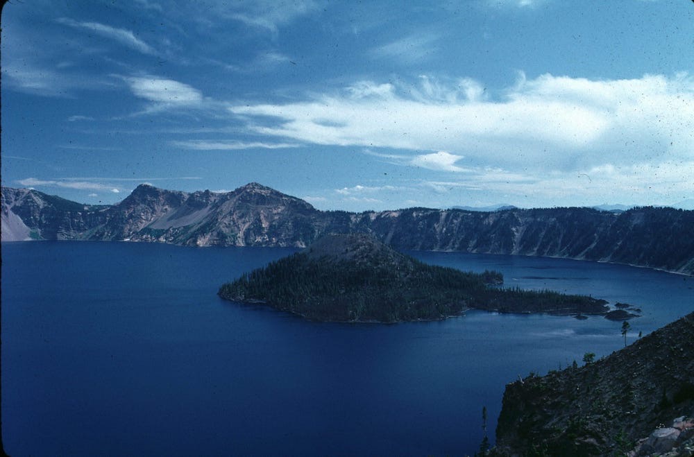 Crater Lake with Wizard Island under a wide blue sky