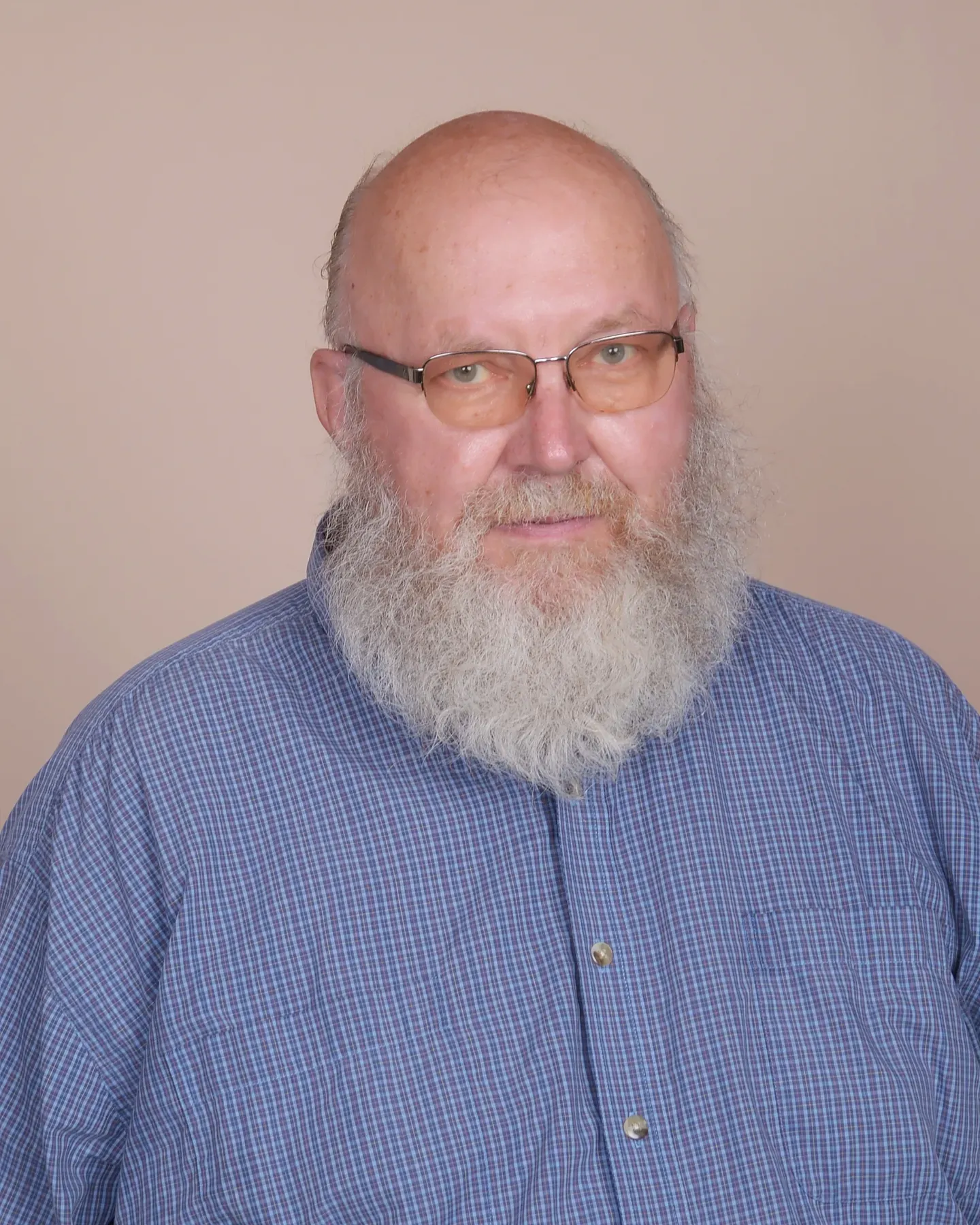 Portrait of Ralph Good, smiling, with glasses and a white beard